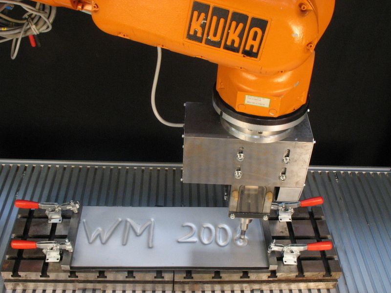 Bild 2: Der Roboter prägt in einem hämmernden Umformprozess den zuvor programmierten Text in das Blech. Bilder: Verfasser (Archiv: Vogel Business Media)