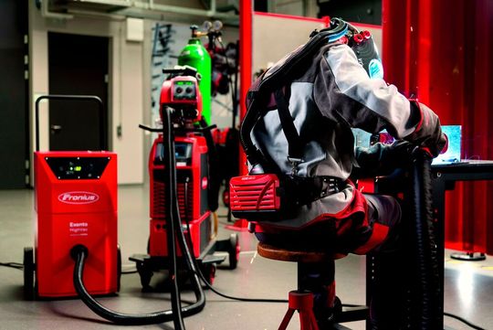 Dieser Schweißfacharbeiter trägt, weil sonst kein System für die Schweißrauchabsaugung möglich war, einen Schutzhelm des Typs Vizor Air/3X Connect von Fronius als persönliche Schutzausrüstung.(Bild:  Fronius)