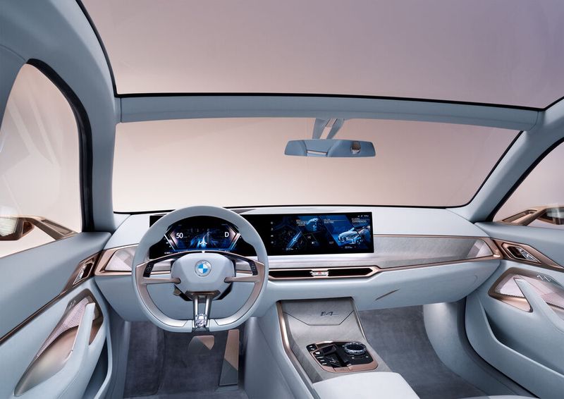 Der aufgeräumte, weiß ausgekleidete Innenraum wird von einem konkaven Curved-Display geprägt. (Bild: BMW)