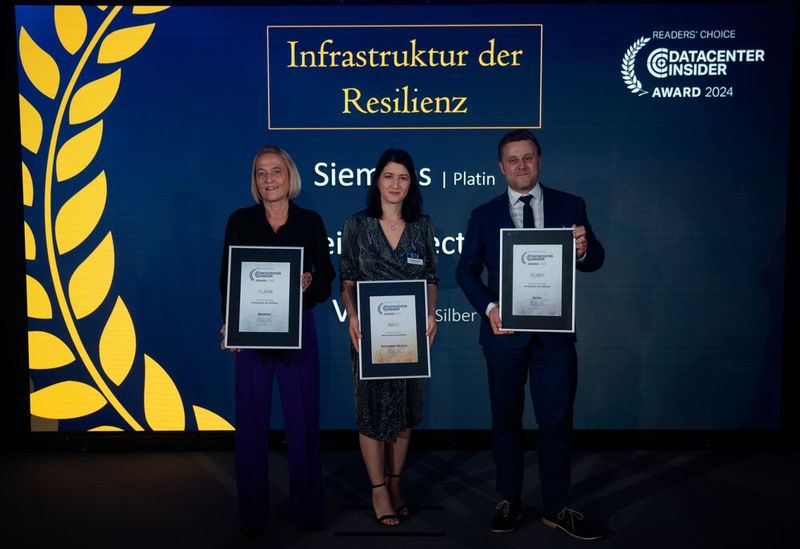 Was dürfen Rechenzentren niemals? Ausfallen! Wer will schon auf Gehalt, Infos und E-Mails vezichten? Gut, dass es Hardware, Software, Services und die diversen Datacenter-Gewerke gibt, die dem Blackout entgegenstehen! Die Gewinner in der Kategorie „Resiliente Infrastruktur“ sind Vertiv: Silber, Schneider Electric: Gold und Siemens: Platin. Für die Gewinnerunternehmen auf der Bühne: Heike Ludwig für den Platin-Preisträger Siemens, Andreea Burceag für die goldglänzende Company Schneider Electric und Christian Gansen für Silber-Abstauber Vertiv.  (Bild: Manuel Emme Fotografie )