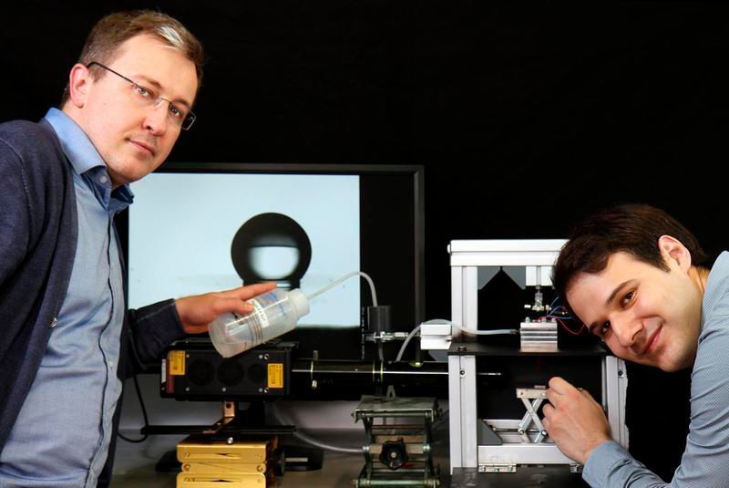 Fabian Krull und Prof. Dr. Sergiy Antonyuk (l.) untersuchen mit einem 3D-Hochgeschwindigkeitskamera-System, wie Tropfen auf unterschiedliche Oberflächen auftreffen. (TUK/Thomas Koziel)