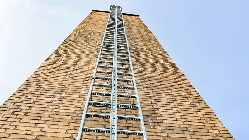 Steigleiter mit integrierter Steigschutzschiene für den 20 Meter hohen Schornstein des Technikgebäudes am Klinikum Heilbronn.(Bild:  Munk Günzburger Steigtechnik)