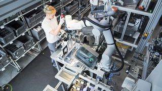 The helping third hand: A cobot precisely positions 60-centimeter-long, flexible LED light module strips on the workpiece so that an employee can screw down the already positioned part of the strip. Robot and human work on the workpiece simultaneously. (Image:ABB AG)