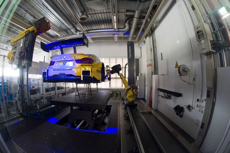 Wie von Geisterhand gelenkt fahren die beiden Roboterarme den neuen BMW M4 DTM ab, scannen die Karosserie mit allen Aerodynamik-Komponenten Millimeter für Millimeter und erstellen vollautomatisiert das perfekte 3D-Modell. (BMW/Martin Hangen)