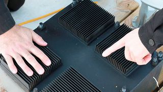 Die Nahaufnahme zeigt den thermischen Resonator (Black Box) mit seinen Kühlrippen über der Oberseite. Das Gerät ist mit einem Phase-Change-Material gefüllt, das es ermöglicht, Energie aus wechselnden Temperaturen aufzunehmen. (Melanie Gonick / MIT)