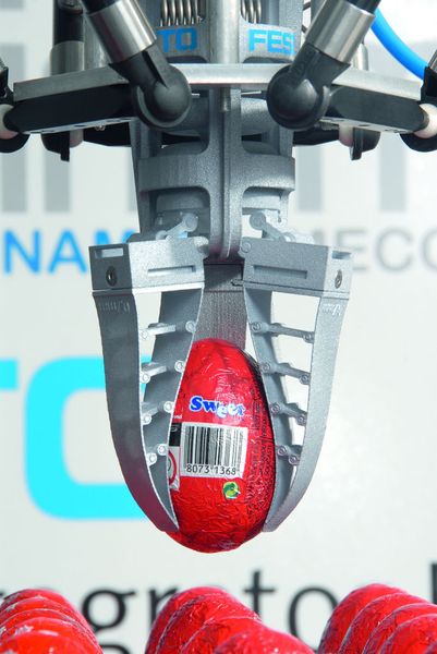 Sanfter Fingripper von Festo: Die Greiffinger umschließen die Kontur der Schokoladeneier vollständig, ohne sie zu zerdrücken und ohne deren Hülle aus Aluminiumfolie zu beeinträchtigen.  Bild: Festo (Archiv: Vogel Business Media)