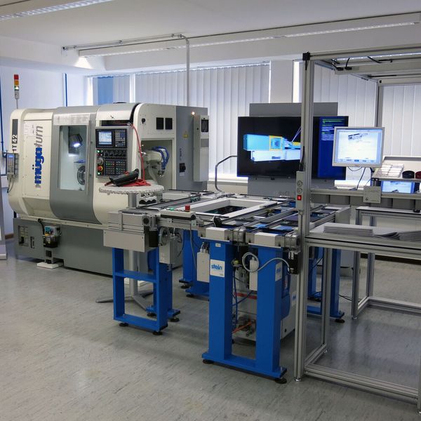 Blick auf die Anlage der Lernfabrik mit Handarbeitsplatz (r.), Transportsystem des Werkzeugträgers und Dreh-/Fräszentrum von müga mit Roboter.  (Bild: Feintechnikschule Schwenningen)