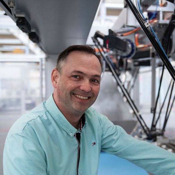 Der Autor Andreas Schildknecht, Produktmanager Robotik bei Syntegon. Im Hintergrund ein Deltaroboter.
 (Bild: BOSCH PACB-MKT)