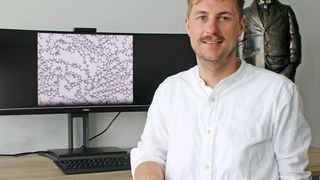 Prof. Dr. Christopher Kuenneth, Universität Bayreuth. Der Bildschirm zeigt die atomistische Struktur eines Polymers mit Kohlenstoff-Atomen (graue Kugeln) und Wasserstoff-Atomen (weiße Kugeln).  (Bild: UBT/ Chr. Wißler)