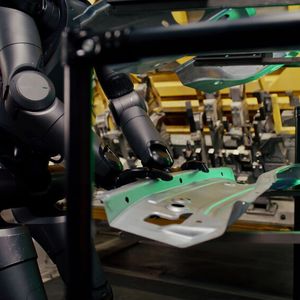 Die Roboter legen Bleche in eine Vorrichtung ein.(Bild:  BMW)