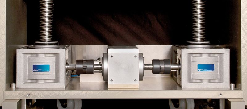Die T-förmige Konstruktion mit den beiden Spindelhubgetrieben und dem zentralen Kegelradgetriebe zum schnellen Aufbau der Presskraft für den Extraktionsvorgang. (Bild: Nozag)