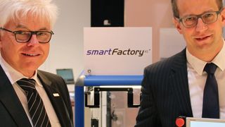 Prof. Detlef Zühlke, Vorstandsvorsitzender der Smartfactory-KL-Initiative und Forschungsbereichsleiter am DFKI, sowie Dr. Thomas Bürger, Bereichsleiter Entwicklung Automationssysteme bei Bosch Rexroth, vor der intelligenten Fertigungslinie der SmartfactoryKL auf der Hannover-Messe. (Bild: Bosch Rexroth)