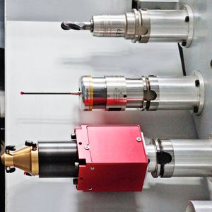 Bild 1: Blick in das Werkzeugmagazin der HSTM-Maschine: oben ein normales Fräswerkzeug, in der Mitte ein Messtaster und unten die Laserschweißeinheit mit rotem Grundkörper.