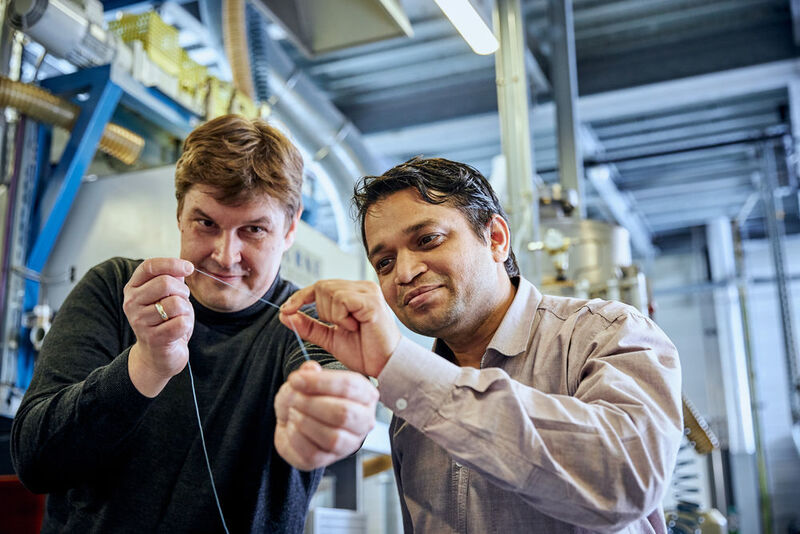 Wissenschaftler Pavan Manvi von der RWTH Aachen University (rechts) und Forscher Dr. Jochen Norwig von Covestro zeigen den Prototyp einer Kunststofffaser aus CO2. (Covestro)