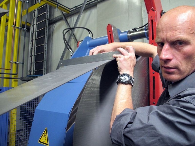 Guido Schneider, technischer Leiter bei SKA, misst die Ebenheit des Coil-Materials im Vergleich zum gerichteten Blechband. (Bild: Schuler)