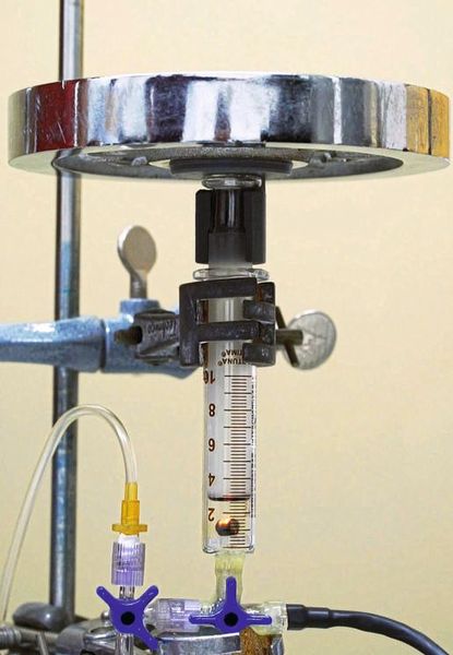 Wie ein Forschungsteam unter Kieler Leitung jetzt herausfand, reichen zum Beispiel wenige Milligramm Aerographen (im Bild am Boden des Druckzylinders) aus, um ein Gewicht von 2 Kilogramm anzuheben – durch einen Luftstoß, der beim Erwärmen des Materials entsteht.  (Bild: Florian Rasch)