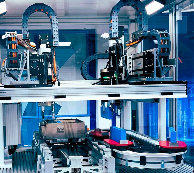 Mit einer Kombination aus realen Exponaten und einer virtuellen Gigafactory zeigt Bosch Rexroth auf der Hannover Messe ausgewählte Prozessschritte einer hochleistungsfähigen Batteriefertigung. Unter der Prämisse eines größtmöglichen Durchsatzes werden die komplexen Wertströme am Beispiel einer Rundzellmodul-Montage erlebbar: vom virtuellen Lager, der Zellvorbereitung über die Modul- und Packmontage bis hin zum Transport und der End-of-Line-Prüfung. Hannover Messe 2025: Halle 6, Stand D26 (Bild: Bosch Rexroth)
