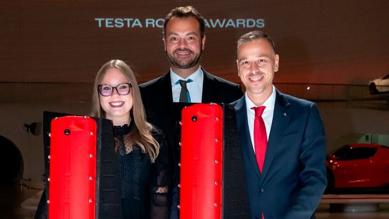 Die deutschen Preisträger Charlotte Kubicki und Pietro Fois bei der Verleihung der Testa Rossa Awards 2025 in Maranello. Im Hintergrund Wilhelm Hegger, Geschäftsführer von Ferrari Central Europe.(Bild:  Ferrari)