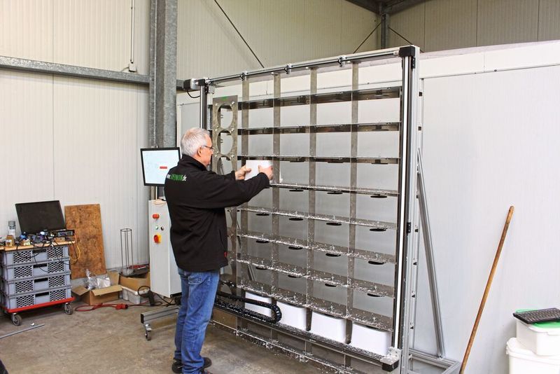 Martin Langhoff setzt Eimer zum automatisierten Bohren der Belüftungslöcher in den selbstkonstruierten Eimerbohrer. (Igus)