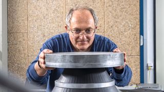 Empa-Forscher Andrea Bergamini setzt ein Gewicht auf den Modell-PAS, um die Nutzlast zu simulieren. (Bild: Empa)