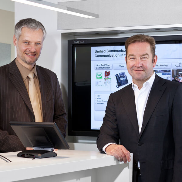 Gerhard Schulz (rechts), Vorsitzender der Geschäftsführung, und Andreas Bichlmeier, Senior Manager UCC, feiern das einjährige Jubiläum des UCC-Democenter von Ingram Micro. (Ingram Micro)