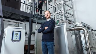 Von unten nach oben: Dr. Simon Jantac und Dr. Holger Großhans sind die Autoren der Studie. Ganz oben steht Dr. Wenchao Xu, der die mehrere Meter hohe Apparatur zur Untersuchung der elektrostatischen Aufladung von Staub konstruiert hat und betreut. (Bild: Physikalisch-Technische Bundesanstalt)