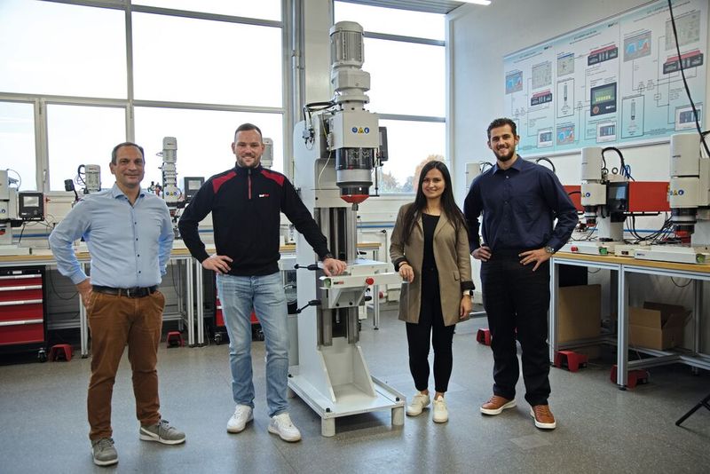 Maurizio Di Domenico, Sandro Keller, Marketingmanagerin Alisha Moosmann und Steve Schaffner an der Baltec­Radialnietmaschine RNE481-HPP mit der Gribi-Hydraulikanlage. (Bild: Matthias Böhm)