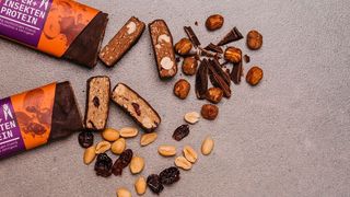 Krabbler-Knabber! Das sind (nur als Beispiel) Nahrungsriegel, die aus Getreide und Insektenproteinen bestehen. Die automatische Herstellung von wertvollem Insekteneiweiß will der Food-Konzern Aspire jetzt mithilfe von Dematic-Know-how in Angriff nehmen. (Krabbeltiger)