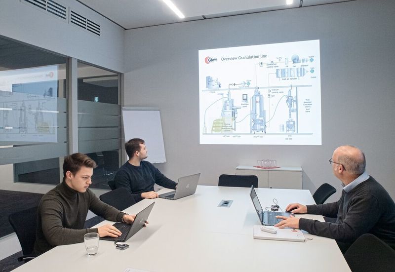 Teambesprechung – im Bild das Anlagenlayout einer Granulationslinie (Glatt)