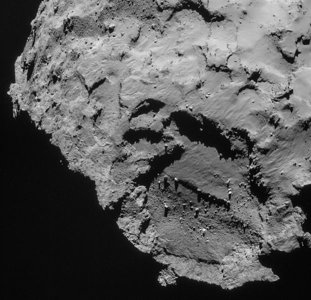 Dieses Bild der Landestelle J auf dem Kometen 67P/Churyumov-Gerasimenko wurde am 21. September 2014 von der Navigationskamera an Bord der Raumsonde Rosetta aus etwa 27,8 km Entfernung zum Kometen aufgenommen. Der abgebildete Bereich ist 2 × 1,9 km groß. Die Landestelle befindet sich leicht überhalb der markanten Vertiefung, die auf diesem Bild zu sehen ist. (Bild: ESA)