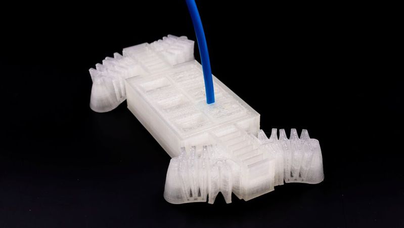 Was hier wie eine Eiswürfelform aussieht, ist in Wirklichkeit ein Steuermodul für einen Softroboter. Das Besondere ist, dass es additiv gefertigt wurde. Softroboter brauchen damit für gezielte Bewegungen keine Elektronik mehr, was sie für bestimmte Einsätze prädestiniert.(Bild:  Universität Freiburg / L. Brunold)