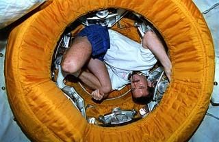 Die Platzverhältnisse innerhalb der MIR waren generell sehr beengt (hier zu sehen: NASA-Astronaut Chris Hadfield, der die gesamten Verfügbaren Platzverhältnisse im Docking Modul demonstriert). (NASA)