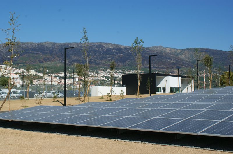 1.610 Solar-Paneele können zu 30 Prozent des Strombedarfs im Rechenzentrum beitragen. Der Blick fällt auf den Eingangsbereich; Hier findet eine erste Personenkontrolle statt.  Im Hintergrund: Die Berge sind schwarz. Dort hat es im August gebrannt.  (Ulrike Ostler)
