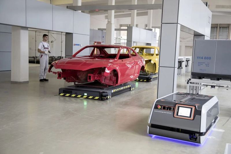 Jeder kennt die Kfz-Montage am Fließband. Audi setzt jetzt zusätzlich auf sogenannte Montageinseln, wie diese. Rechts unten ein autonomes Transportmittel, das die Bauteile heranschafft, was mit ganzen Karosserien klappt, wie es heißt.