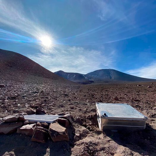 The SO2 camera installation on Lascar Volcano, Chile. The camera is housed inside a protective metal casing, which also holds the battery for powering the instrument; a solar panel for battery charging is located to the left of the box.