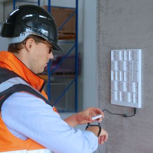 Zum Arbeitsbeginn nimmt der Mitarbeiter den Kinexon SafeTag aus der Ladeschale.