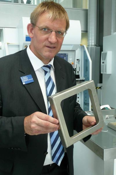 Dr.-Ing. Peter Juchmann, Geschäftsführer der Salzgitter Magnesium-Technologie GmbH, hält ein fertig gekantetes Bauteil aus Magnesium in der Hand; dieses Bauteil zeigt saubere und exakte Kanten. Bild: Kuhn (Archiv: Vogel Business Media)