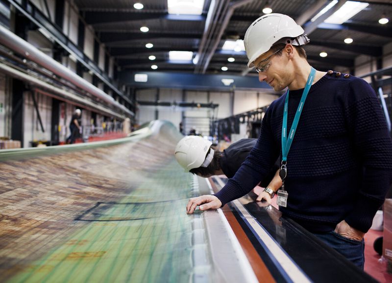 Qualitätsprüfung an einem vor der Auslieferung stehenden Rotorblatt. Ein solcher 154-m-Rotor fängt in der Praxis etwa 200 t Luft in der Sekunde ein. (Bild: Siemens AG)