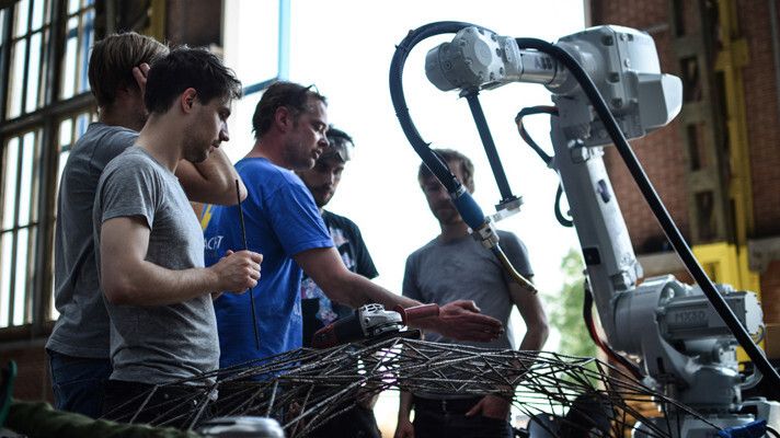 Das Projektteam von MX3D bei ersten Entwürfen der Brücke. Im Bild ist auch der Industrieroboter zu sehen. (MX3D)