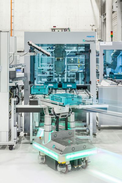 Mithilfe interner und externer Lokalisierungssensoren können sich Fahrerlose Transportsysteme (FTS) zum Beispiel bei der Übergabe von Lasten bis in den Millimeterbereich genau positionieren. (Bild: Fraunhofer-IPA/Rainer Bez)