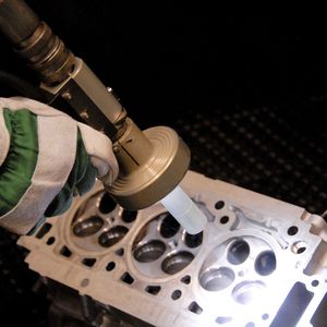 Bild 1: Das Trockeneisstrahlen reinigt oberflächenschonend Zylinderköpfe. In einem Durchgang wird eine hohe Bauteilsauberkeit für anschließende Messungen erreicht.