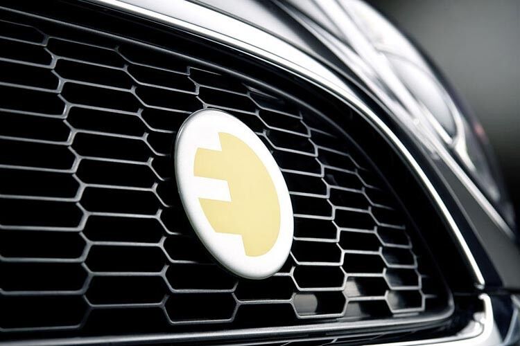 Äußerlich ist der Mini E an einigen Details zu erkennen: zum Beispiel am Emblem am Kühlergrill. Es zeigt einen gelben Stecker in E-Form, der auch auf dem Dach des Fahrzeugs zu finden ist. (BMW)