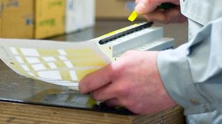 Schaltschrankbau bei Schubs: Ein Elektriker beschriftet einen Sicherungskasten. (Bild: Thorsten Sienk/Schubs GmbH)