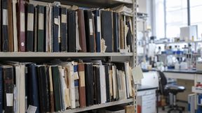 Abb. 1: Überfülltes Regal mit Papierlogbüchern und Ordnern im Laboralltag – Symbolbild für analoges Wissensmanagement. (Bild: KI-generiert)