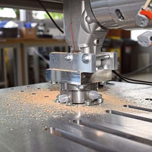 Der 6-Komponenten-Kraft-/Momenten-Sensor von Kistler misst exakt die dynamischen Kräfte und Momente, die auf die Stichsäge einwirken. Die Säge ist kopfüber montiert.