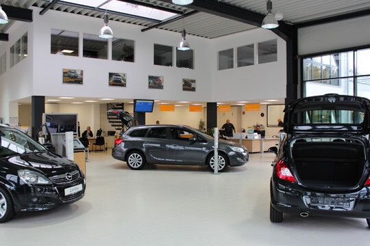 Der großzügige Schauraum: Die versetzt verlegten hellgrauen Fliesen sollen für eine ruhige Atmosphäre sorgen, auf der das aktuelle Opel-Fahrzeugdesign umso besser wirken kann. Nur der Aufsteller am Astra-Kombi muss noch umgesetzt werden – denn der soll nach den Herstellervorgaben immer am linken Vorderrad platziert sein. (Foto: Brass)
