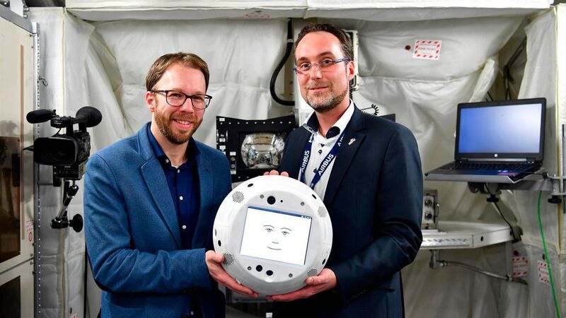 Dr. Christian Karrasch und Till Eisenberg halten Cimon in den Händen. Das intelligente Astronauten-Assistenzsystem soll erstmals diesen Sommer auf der ISS getestet werden.  (DLR/T.Bourry/ESA)