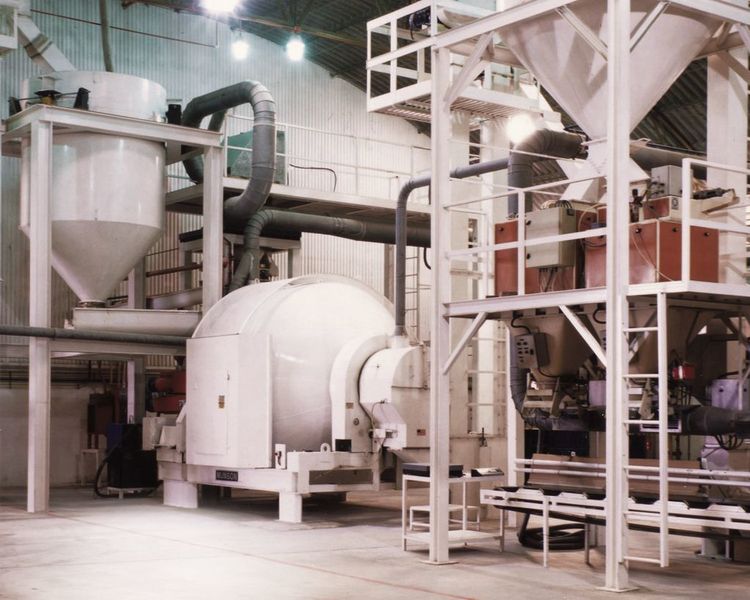 The hopper (at left) feeds clay or quartz granules into the rotary mixer. Chemicals are sprayed as the batch rotates.  (Picture: Indalva S.L.)