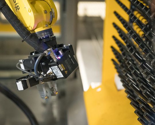 (Alle Kleinteile sitzen auf dünnen Haken. Der Profilsensor OXM200 am Greifer hat zuvor die individuellen Haken mit ihren Positionen erfasst und die Koordinaten an die Steuerung geschickt. Bild: Baumer)