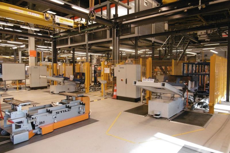 An den beiden Beladestationen positioniert ein Kran die ankommenden Hubgerüste auf den automatisch zugeführten Transportgestellen. Auch diesen Vorgang hat das Automatisierungssystem PSS 4000 sicher im Blick. (Sietatec / Pilz)